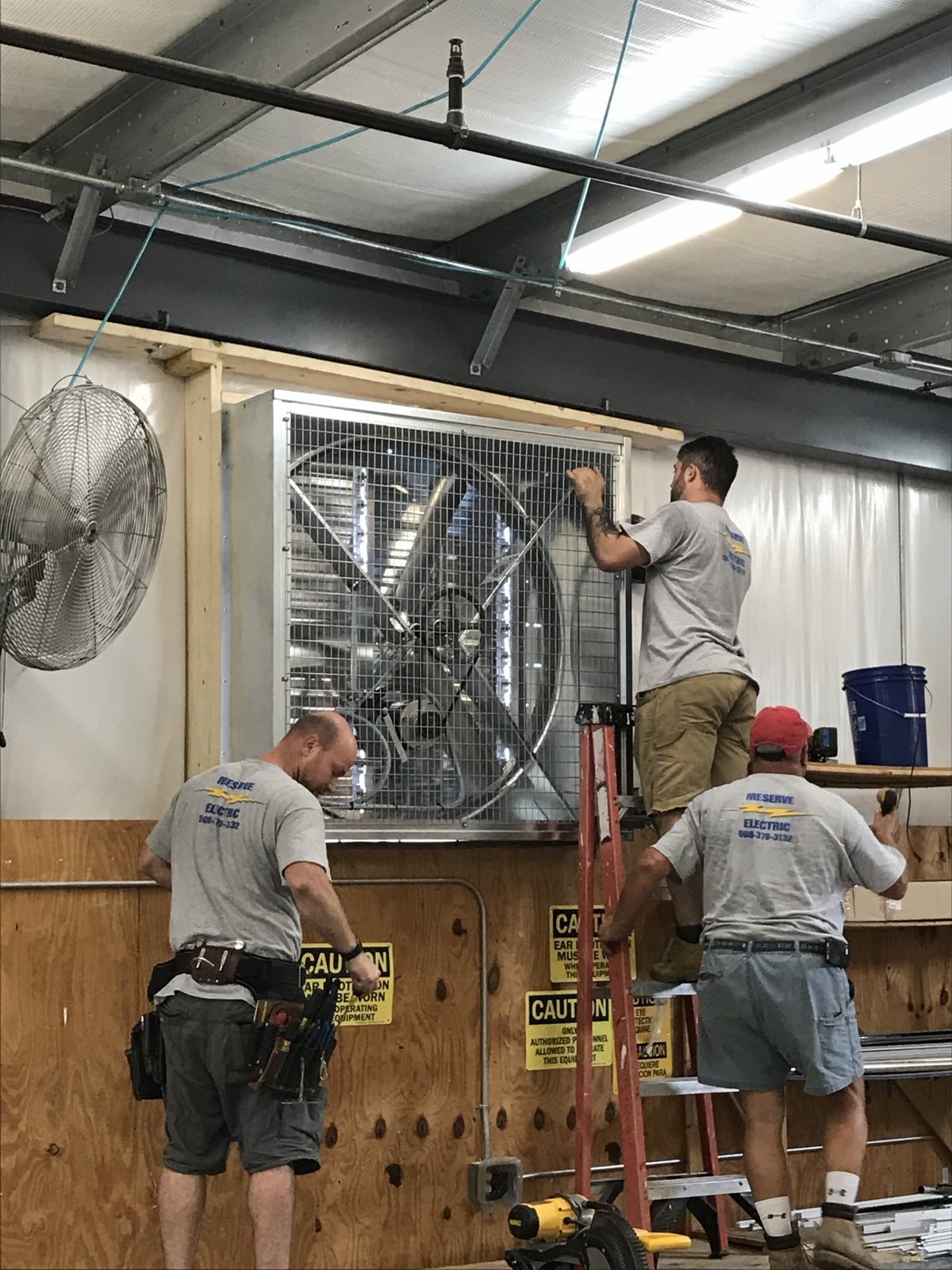 Meserve Electric crew installing a large ventilation fan